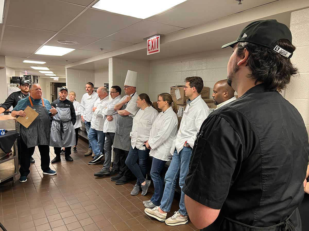 Chef Rosenberg leading a pre-shift meeting with the Thanksgiving volunteers