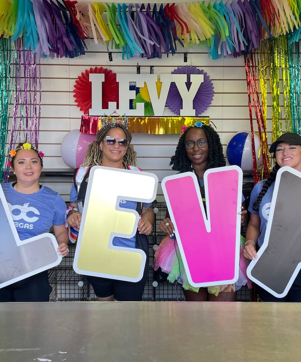 team members holding signs that spell out levy - Mobile