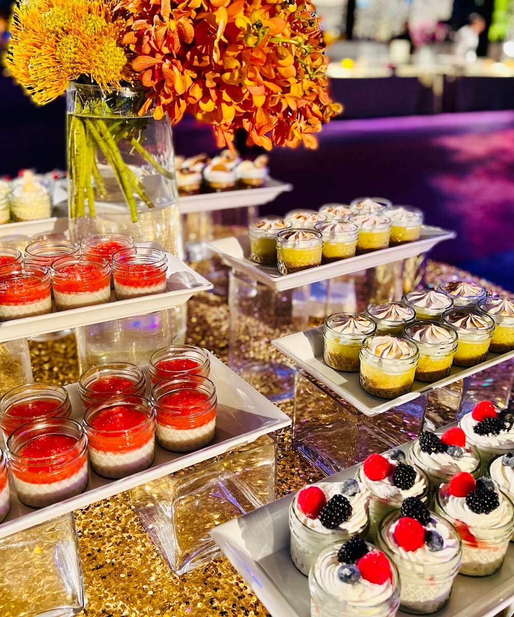 beautiful dessert table with jars of desserts and flowers