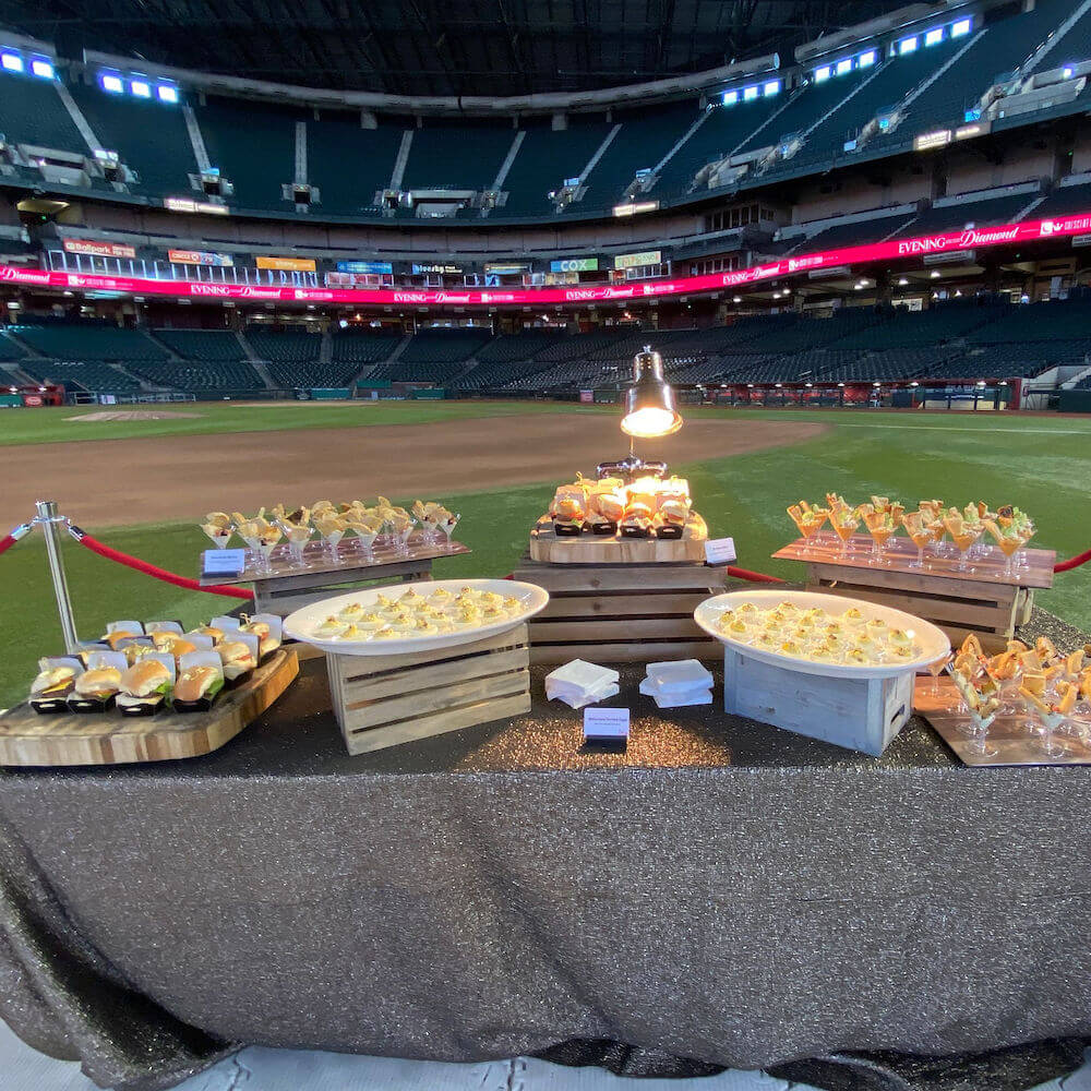 food on a chefs table on a baseball field