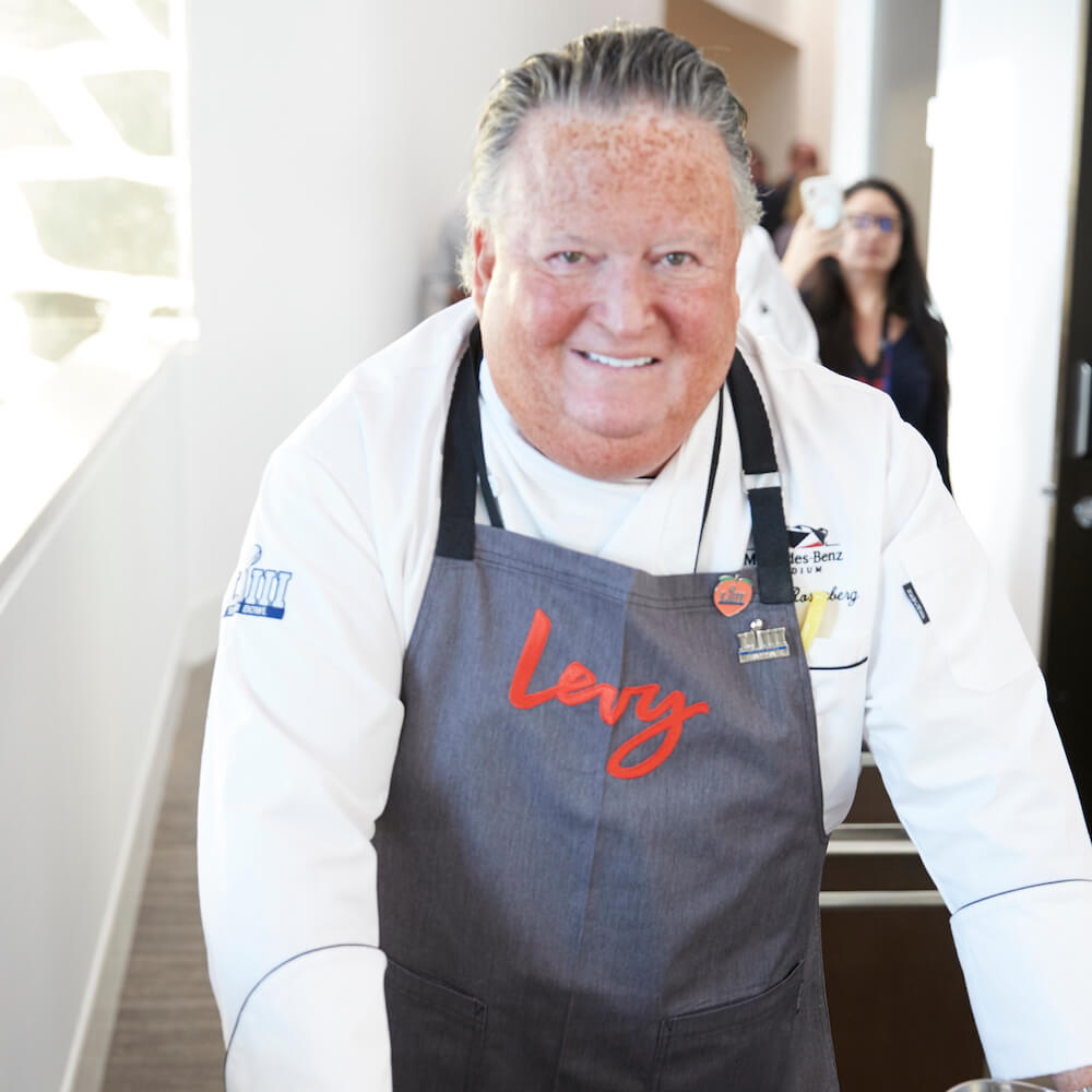 chef pushing a cart of food and smiling