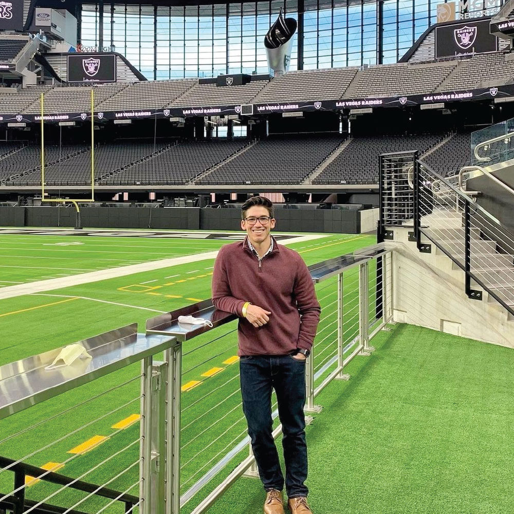 A man standing in front of an empty soccer pitch