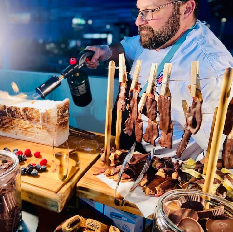 chef roasting a marshmallow at a smore's station