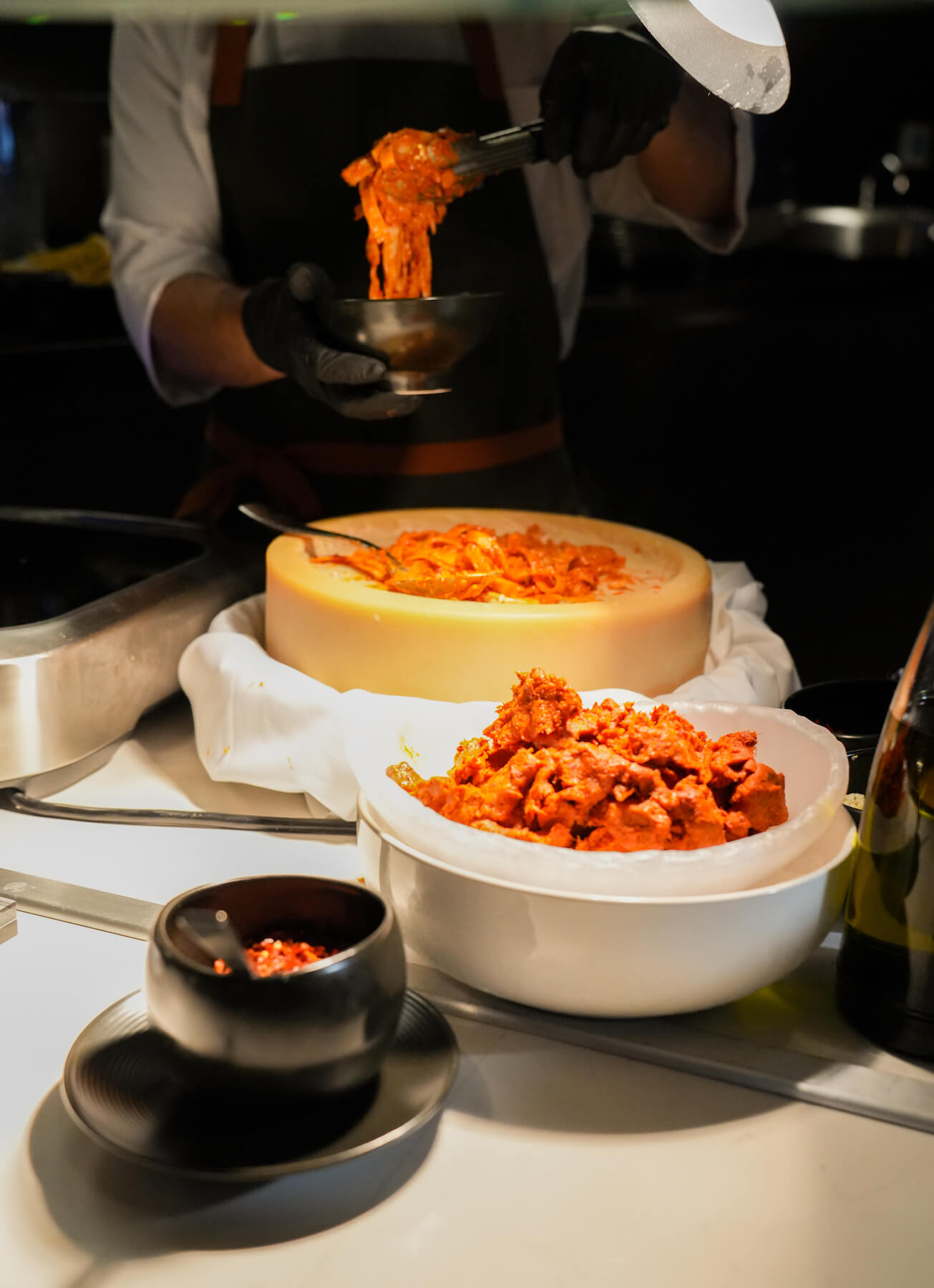 Pasta being served from a cheese wheel