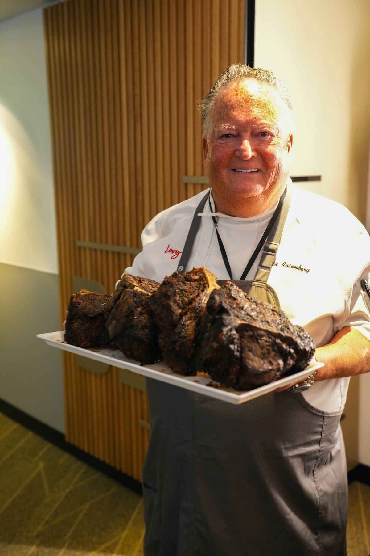 Chef holding plate of smoked meat