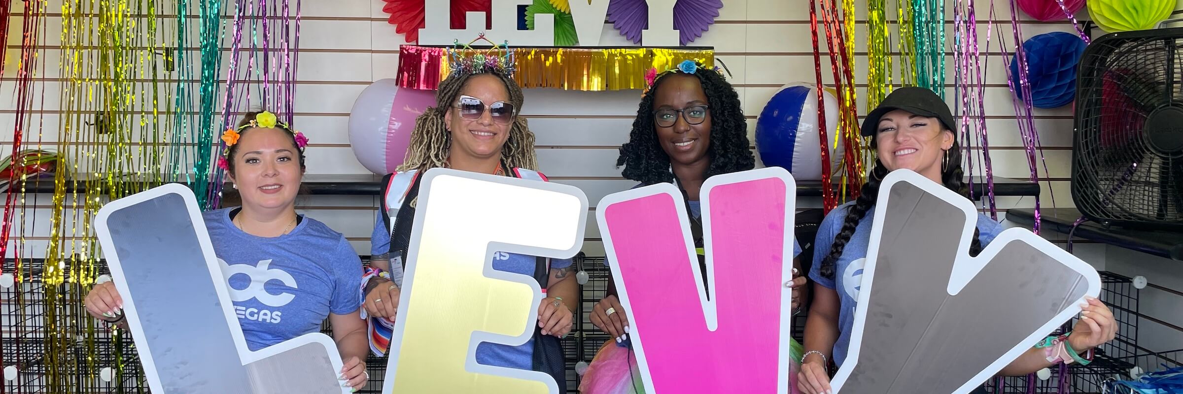 team members holding signs that spell out levy - Desktop