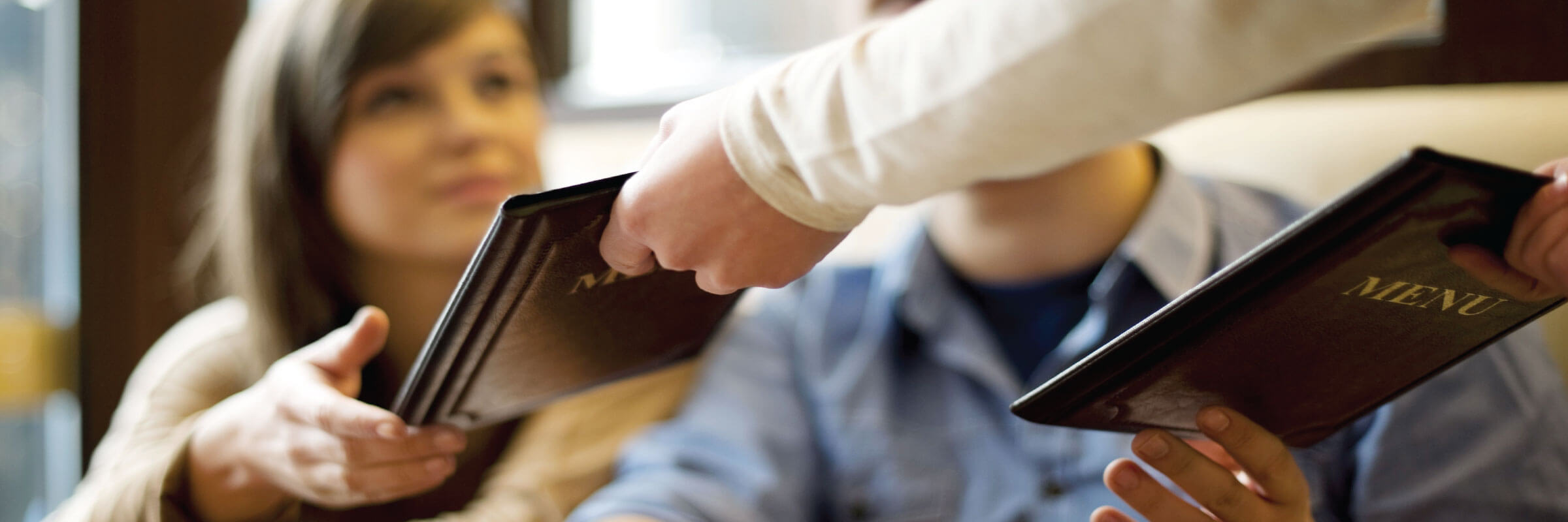 waitress handing menus to patrons - Desktop