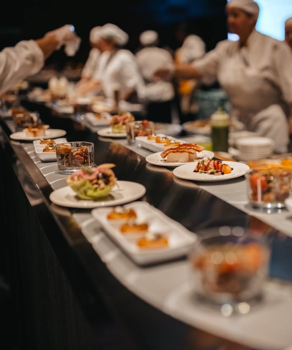 moving conveyor belt with various plates of food displayed