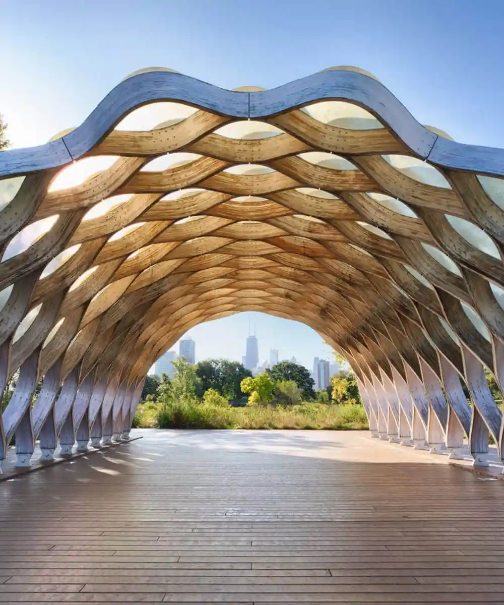 A sculptural gate with a city in the background