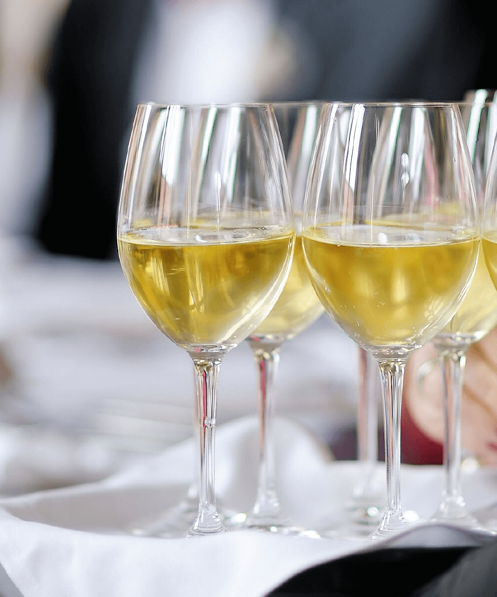 wine glasses being served to a table of guests - mobile version