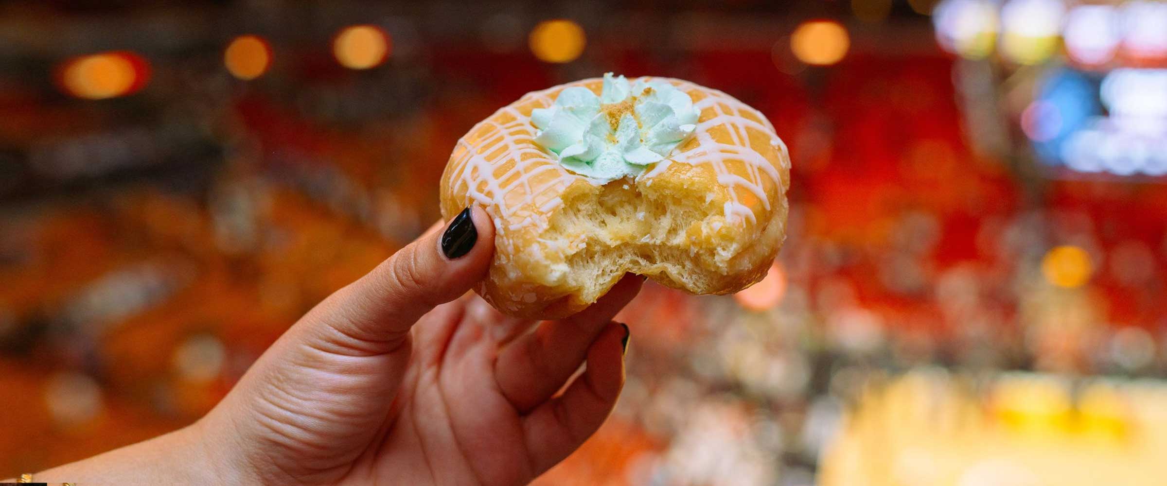 a hand holding a donut in front of a stadium crowd - desktop version